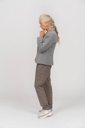 Anciana pensativa en traje de pie de perfil
