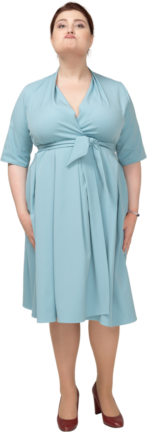 Vue de face d'une femme en robe bleue faisant des grimaces