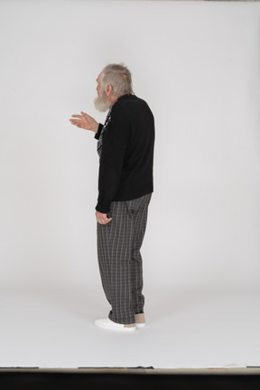 Back view of old man standing with raised arm