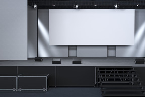 Black stage with projection screen and lighting equipment