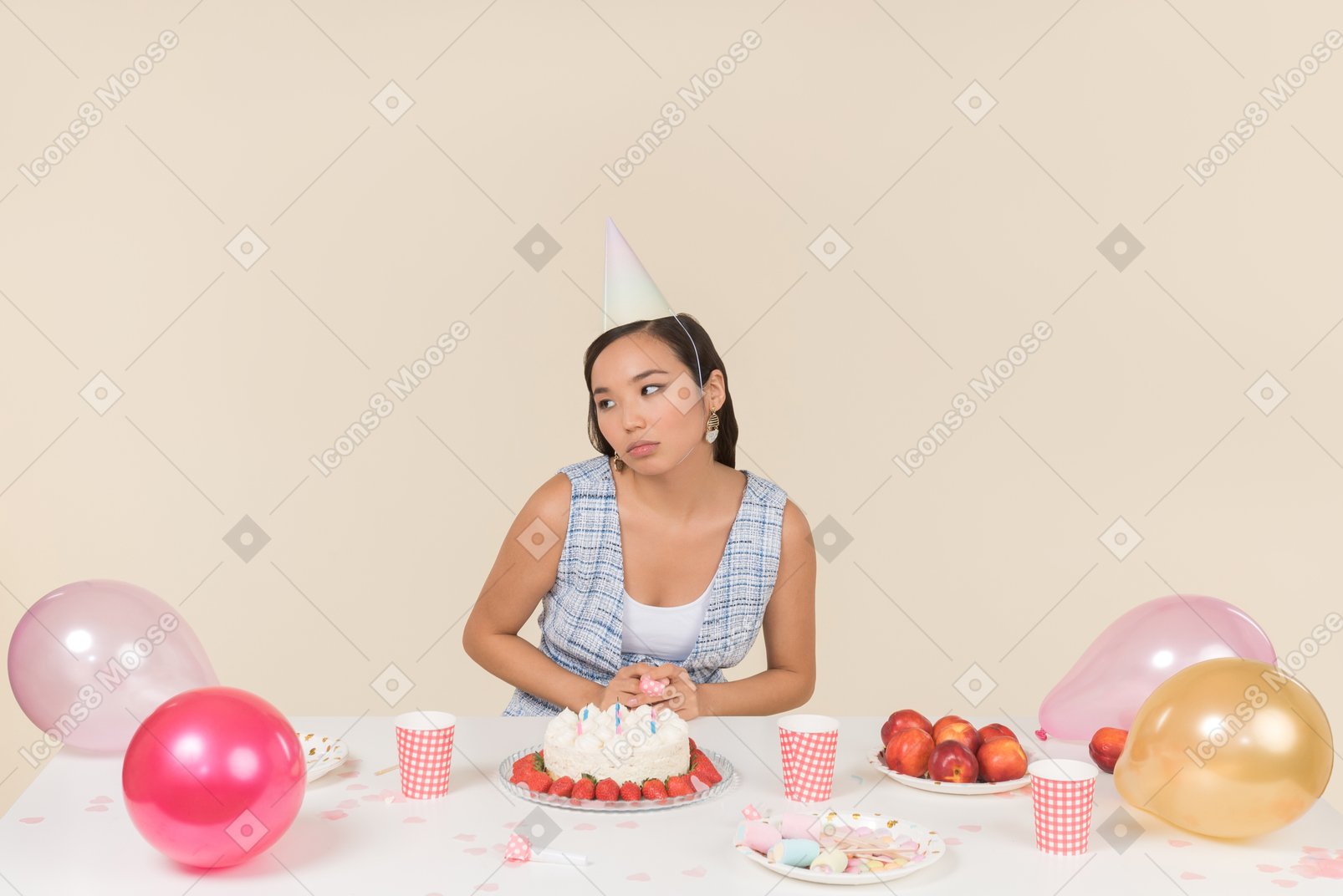 Triste olhando jovem mulher asiática sentado à mesa de aniversário