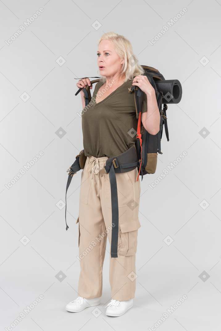 Mature female tourist putting off heavy backpack she was carrying