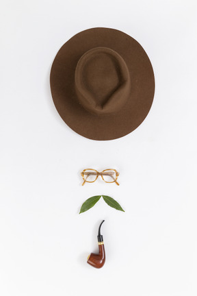 Face made out of hat, eyeglasses and smoking pipe