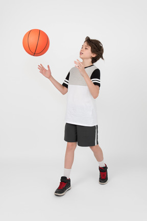 Niño moviendo y lanzando una pelota de baloncesto