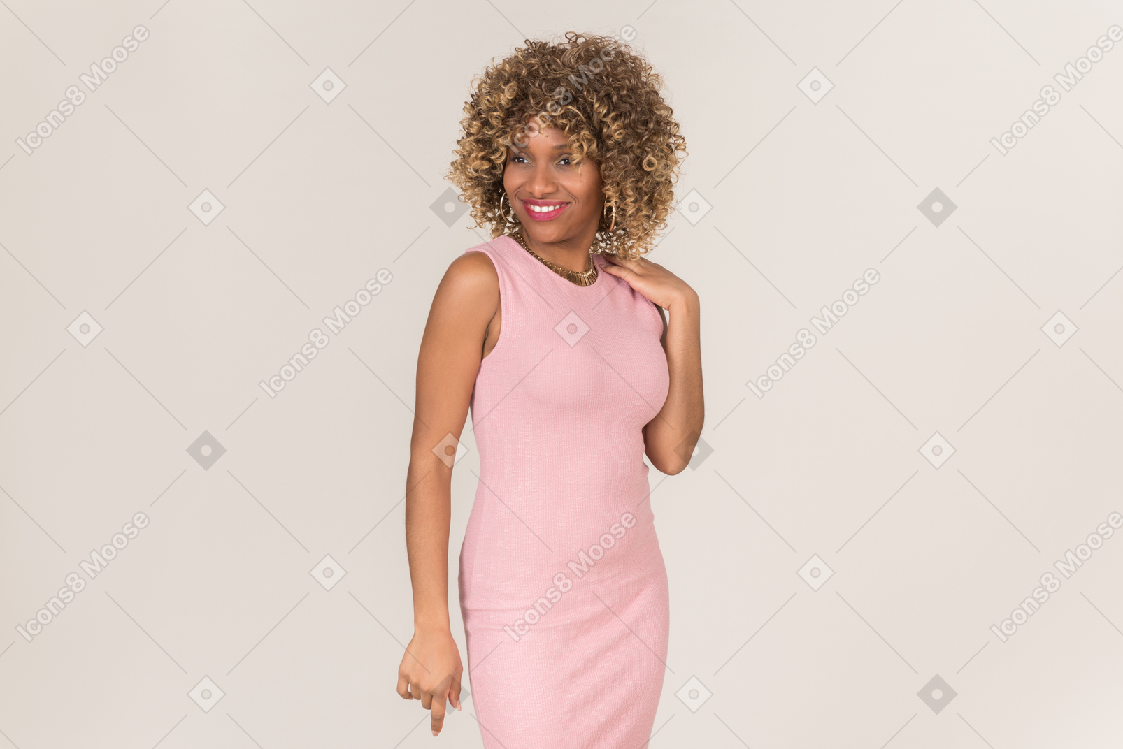 Una donna in abito rosa in piedi e sorridente