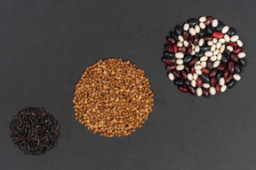 Três círculos feitos de arroz preto de trigo sarraceno e feijão multicolorido