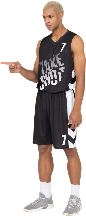 Dreiviertelansicht eines jungen männlichen basketballspielers, der mit dem finger zeigt