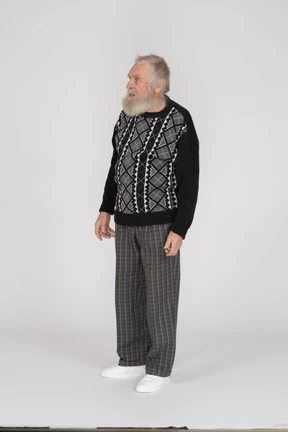 Old man standing with arms at sides and looking aside