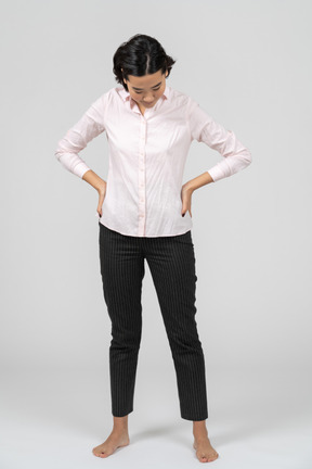 Frau in arbeitskleidung posiert mit den händen auf der taille