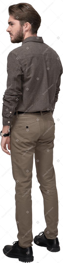 Dreiviertel-rückansicht eines unzufriedenen jungen mannes in bürokleidung, der brauen strickt