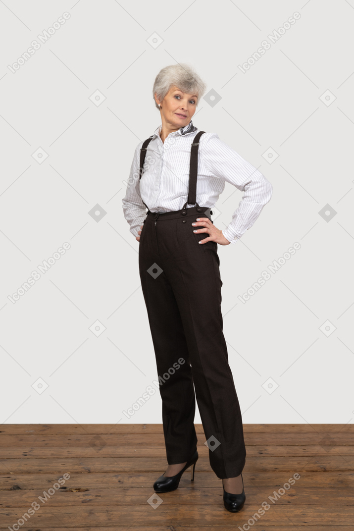 Mujer vestida formalmente posando con las manos en las caderas