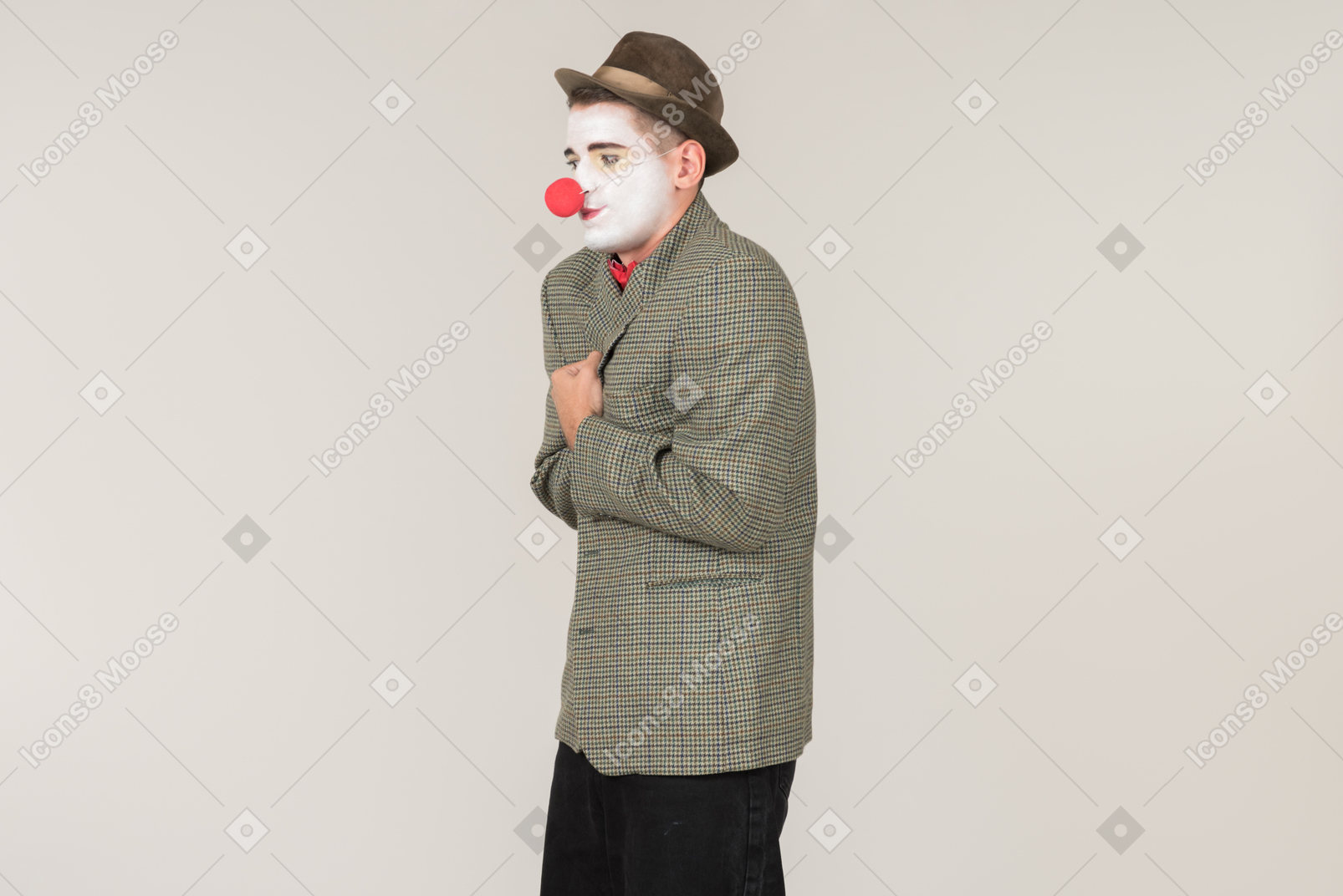 Male clown standing half sideways and wrapping up in jacket
