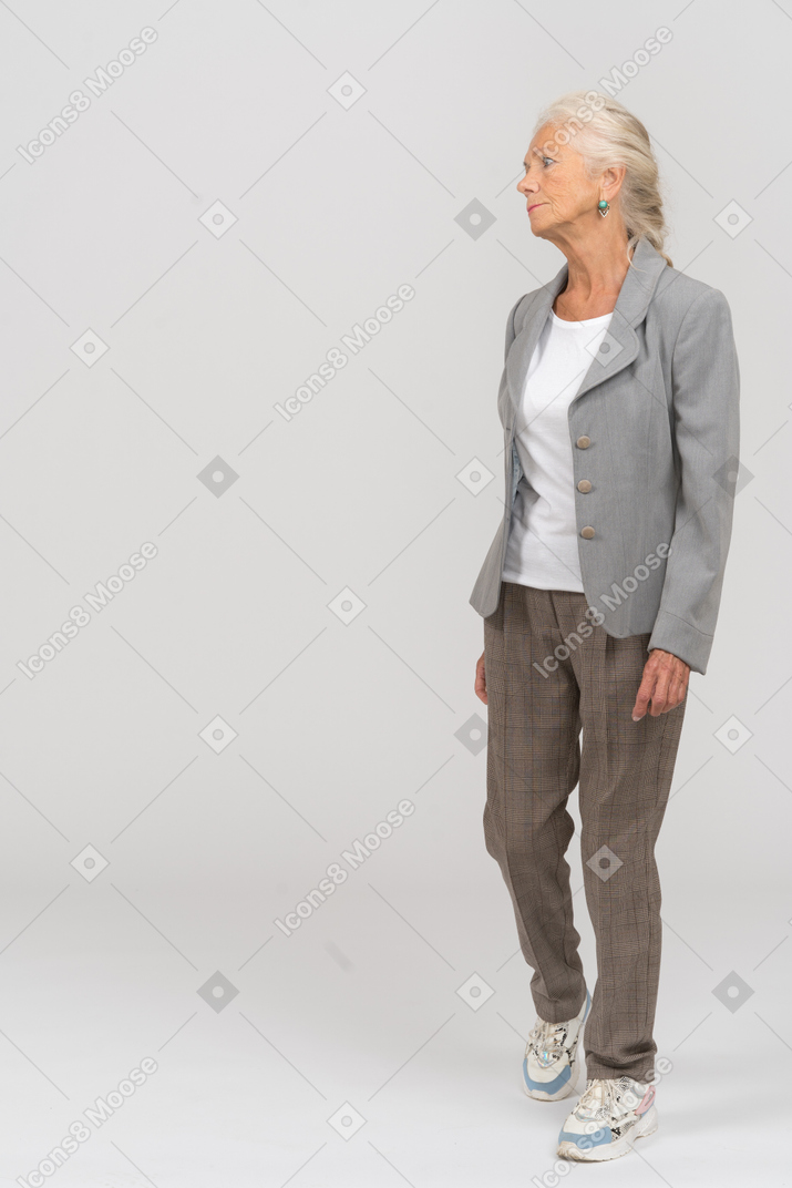 Front view of an old lady in suit walking forward