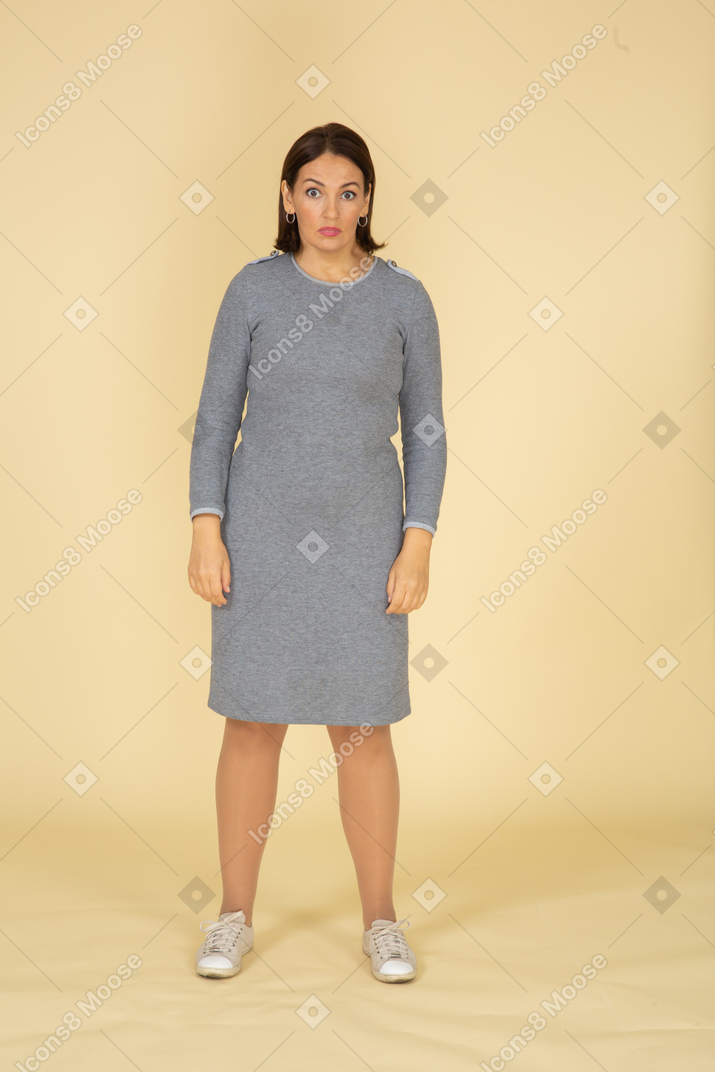 一个穿着灰色裙子的悲伤女人的前视图