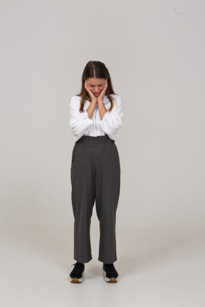 Front view of a young lady in office clothing touching ears