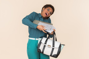 Держа сумку и документы молодая женщина выглядит как спешит