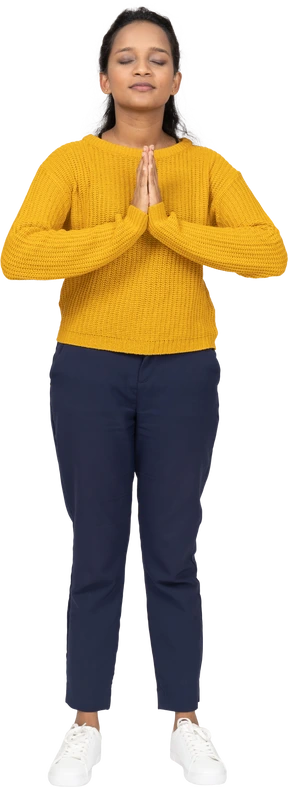 Front view of a girl in casual clothes making praying gesture
