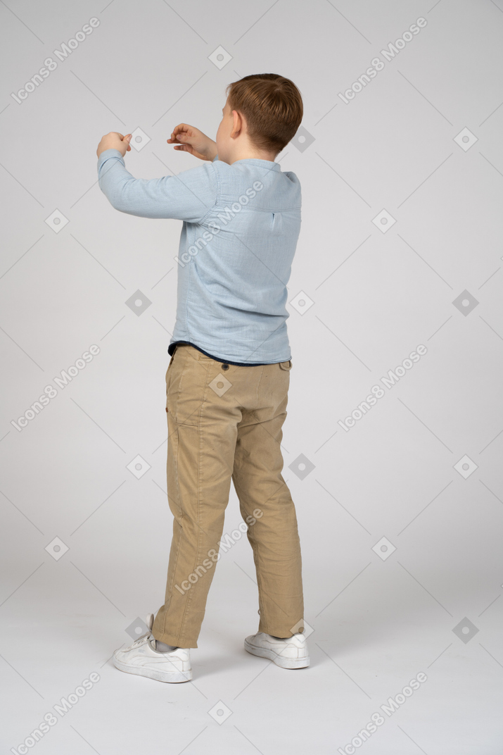 Back view of a boy reaching for something