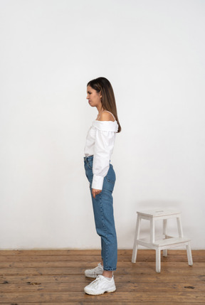 Young woman in casual clothes standing in profile