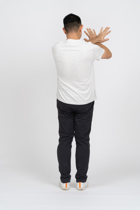 Vista traseira de um homem em roupas casuais, mostrando o gesto de parada