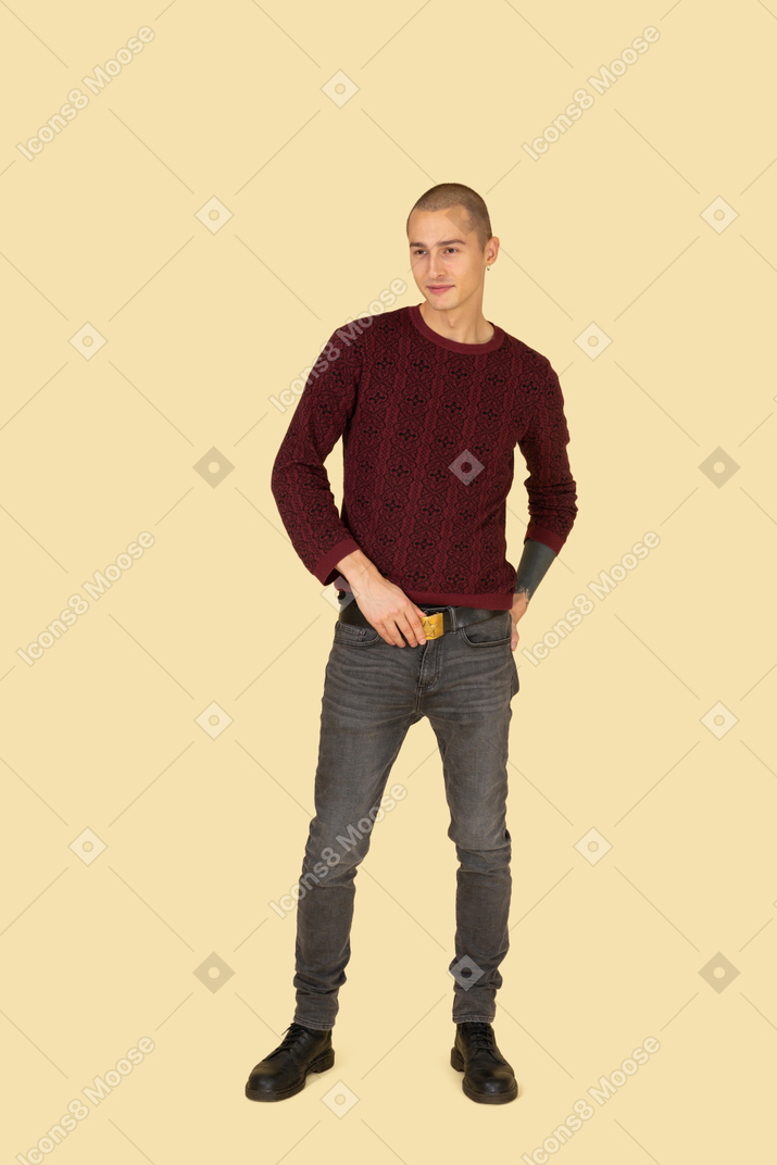 Vista frontale di un giovane uomo in pullover rosso che tocca la sua cintura
