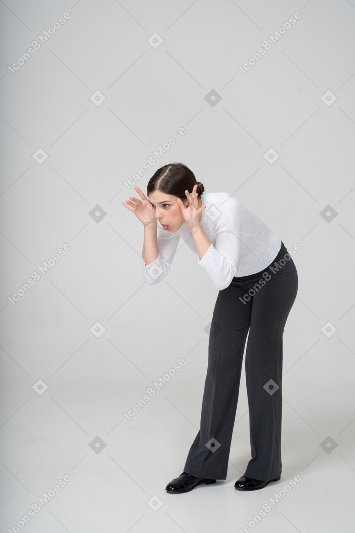 Vue de face d'une femme en pantalon noir faisant des grimaces