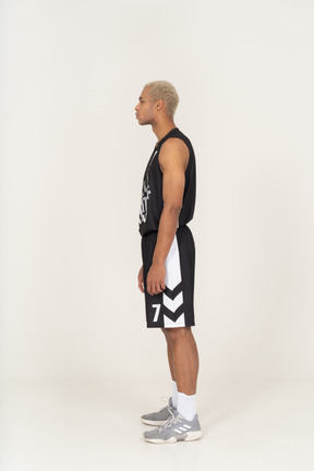 じっと立っている若い男性のバスケットボール選手の側面図