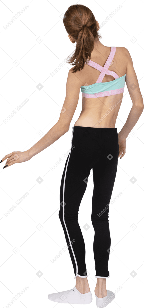 Vista posterior de una jovencita en ropa deportiva inclinando los hombros