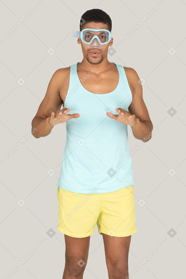 A man wearing a diving mask, blue tank top and yellow shorts