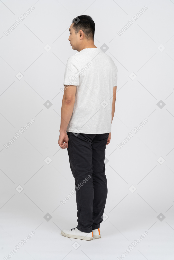 Вид сзади на мужчину в повседневной одежде, смотрящего в сторону