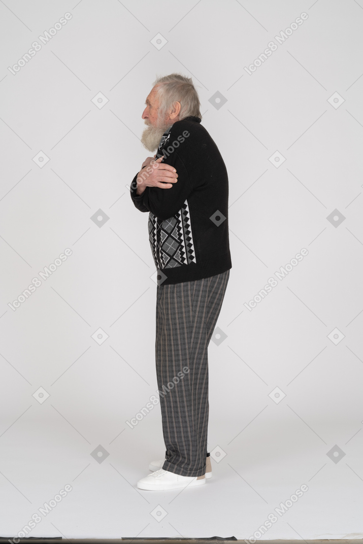 老人拥抱自己的侧视图