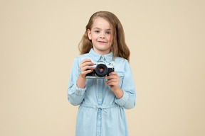 Menina bonitinha segurando uma câmera