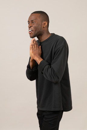 Three-quarter view of a man with praying gesture