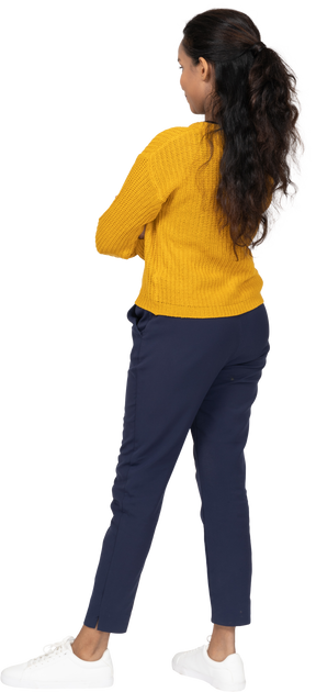 Rear view of a girl in casual clothes standing with crossed arms