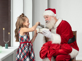 Маленькая девочка принимает подарок от санта-клауса