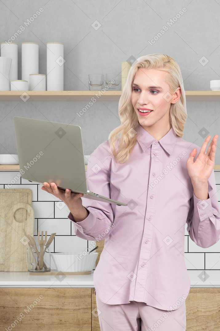 A woman in a pink shirt is holding a laptop