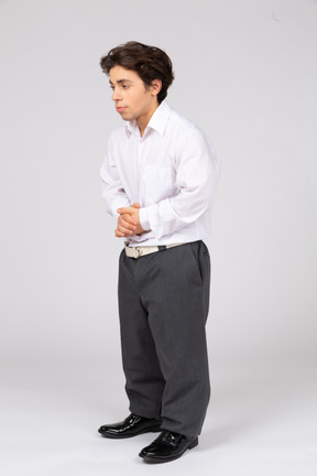 Side view of man standing with his hands folded