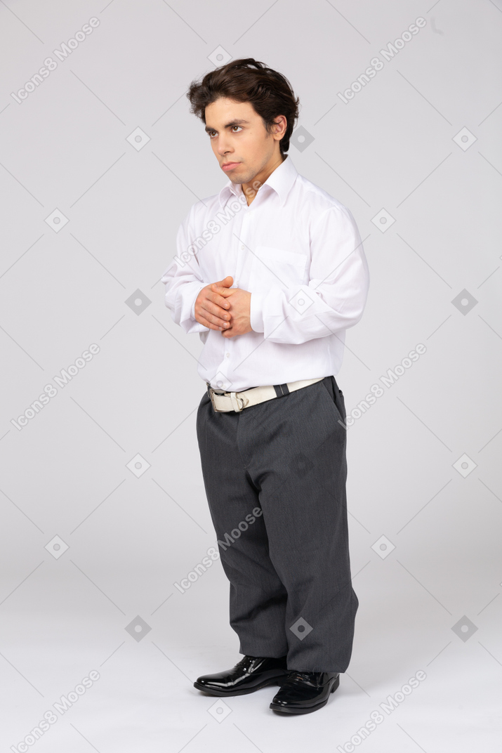 Homem em roupas casuais de negócios em pé com as mãos cruzadas