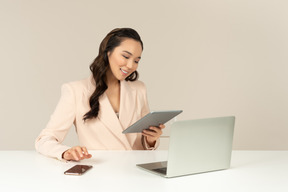 Empleado de oficina femenino asiático mirando tablet