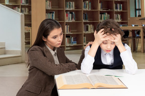 A female teacher looking at tired student in class