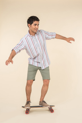 Smiling young caucasian guy standing on skate