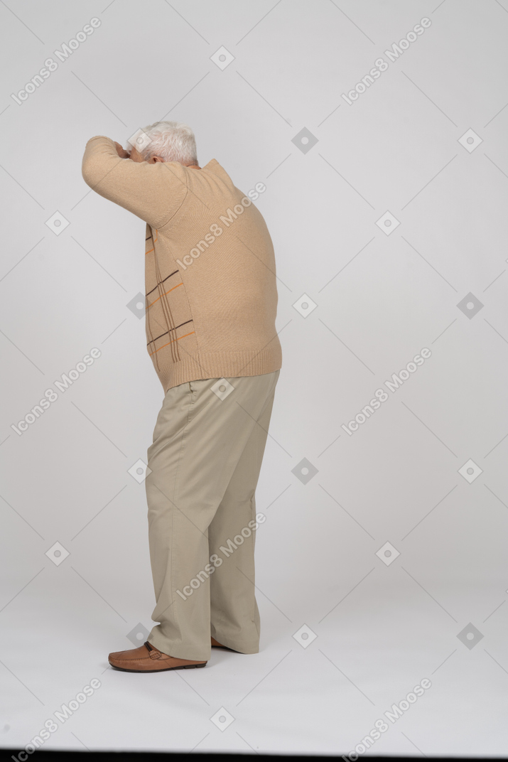 Side view of an old man in casual clothes searching for someone