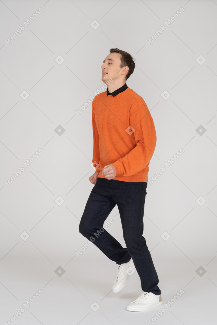 Jovem de moletom laranja andando