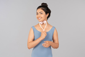 Young indian woman using face massager