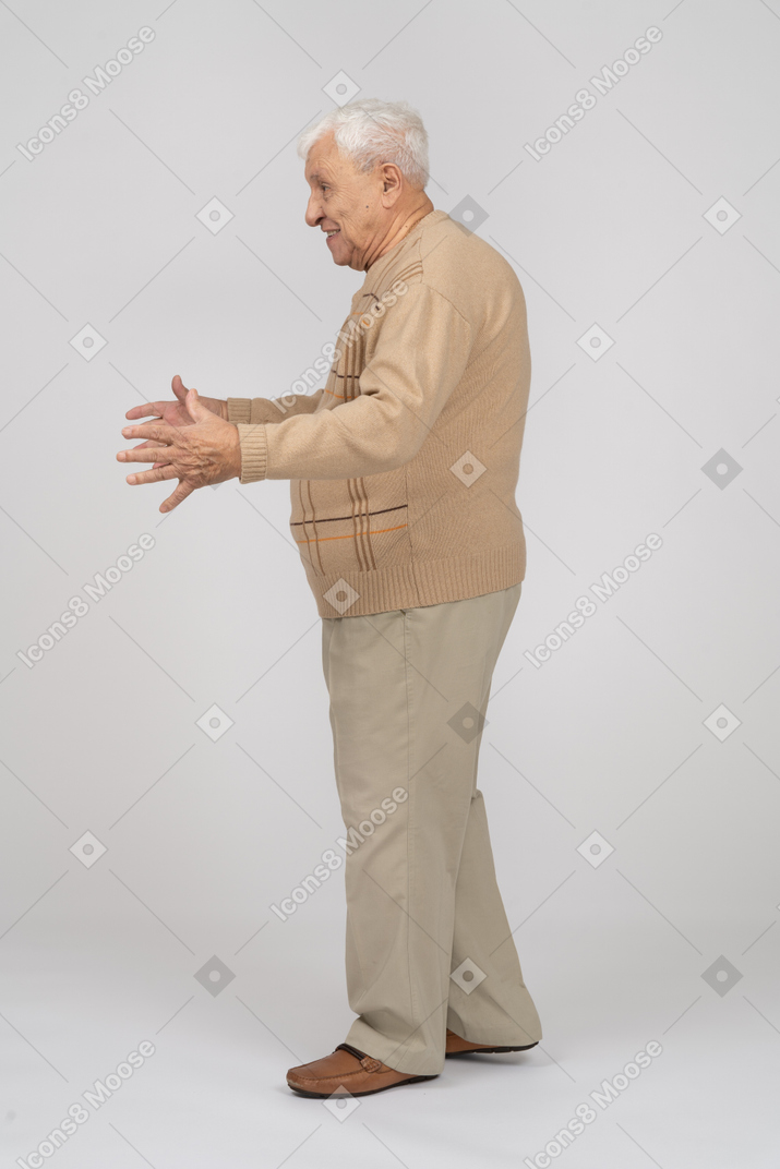 Vista laterale di un vecchio in abiti casual che mostrano le dimensioni di qualcosa