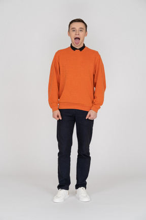 Young man in orange sweatshirt standing