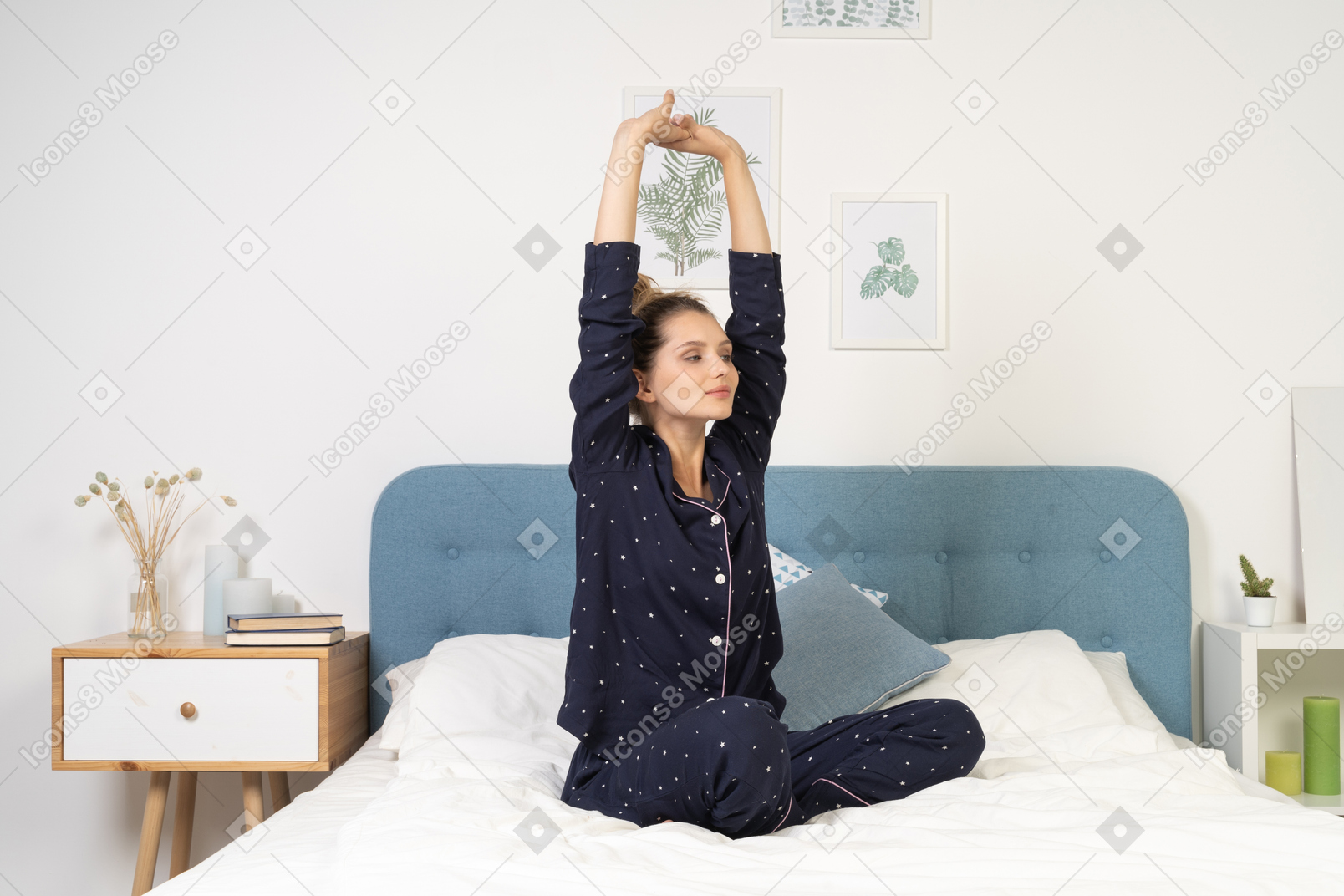 Vista frontal de uma jovem se espreguiçando de pijama na cama