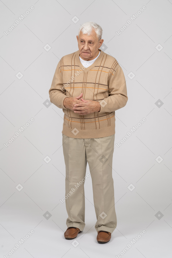 一位穿着休闲服的老人感兴趣地看着某物的正面图