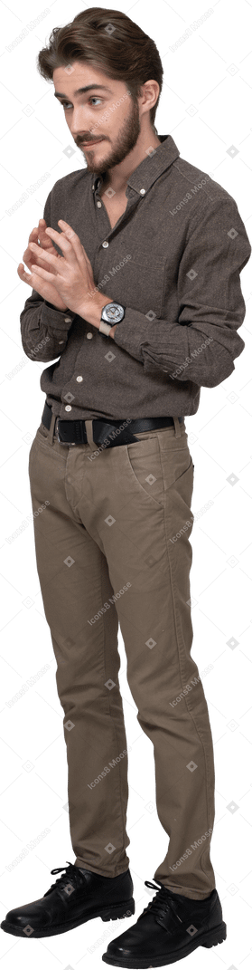 Dreiviertelansicht eines schlauen jungen mannes in bürokleidung, der händchen hält