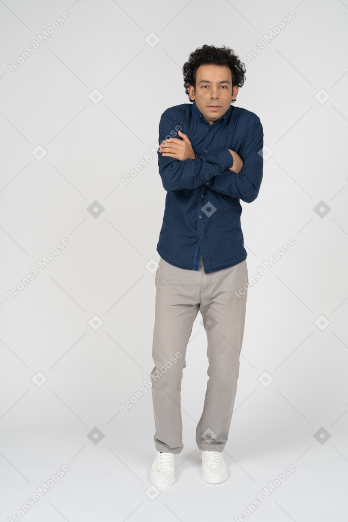 Vista frontal de um homem com roupas casuais posando com os braços cruzados